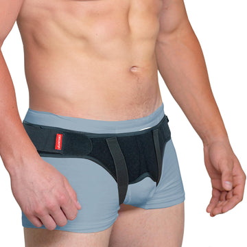 ORTONYX inguinal hernia belt truss on male model, dual removable pads and adjustable hook-and-loop straps for groin support.
