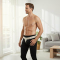 Model wearing beige inguinal hernia truss with contoured pad and hook-and-loop straps, slim under leggings USACHB7270L