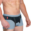 ORTONYX inguinal hernia belt truss on male model, dual removable pads and adjustable hook-and-loop straps for groin support.