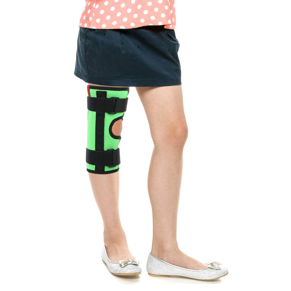 Child wearing ORTONYX Kids Tri-Panel Knee Immobilizer ACJB2117GR, green wrap with open patella and hook-and-loop straps