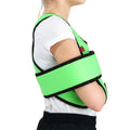 Child wearing green ORTONYX ACJB2409 kids arm sling shoulder immobilizer brace with swathe wrap and hook-and-loop closure