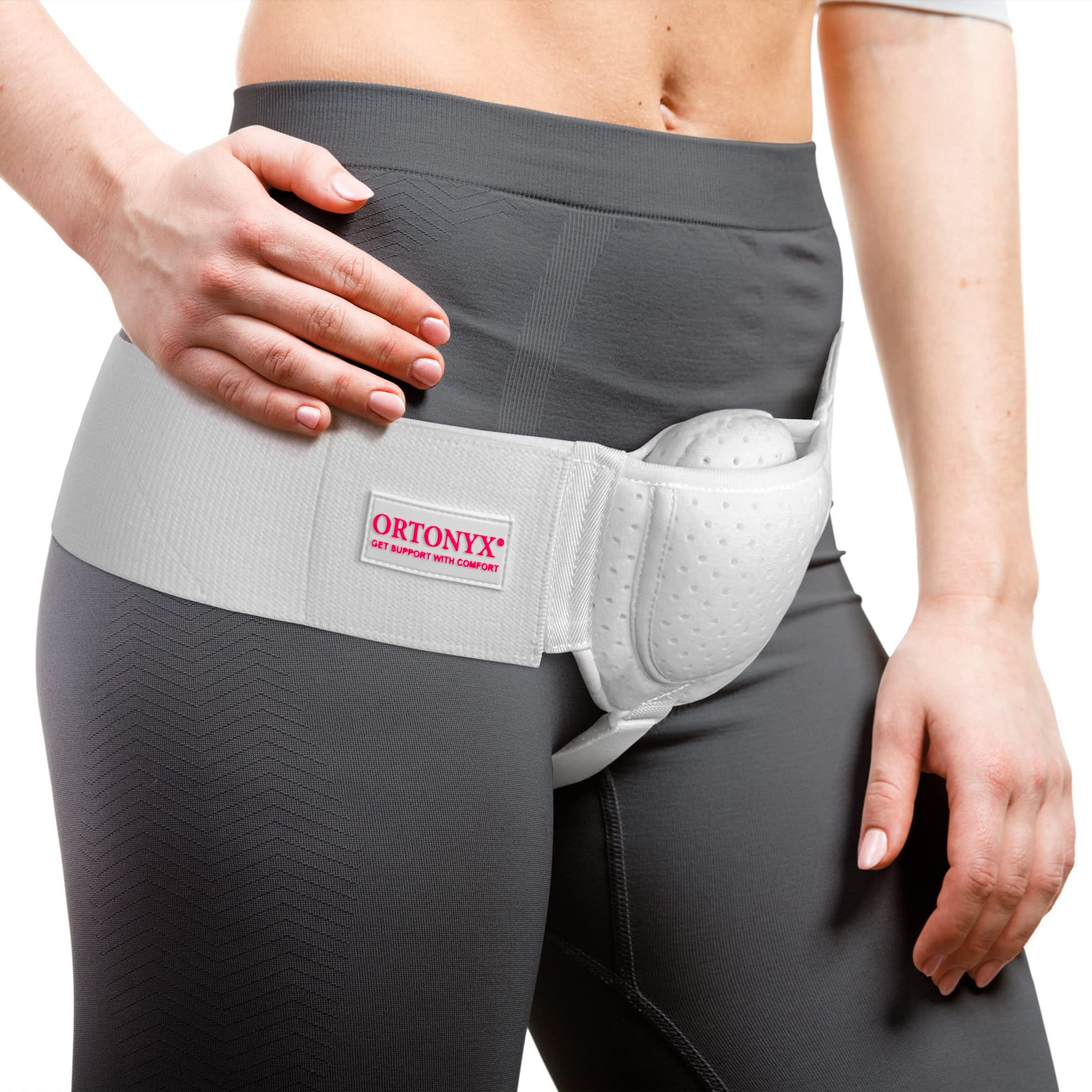 ORTONYX inguinal hernia truss on model, right‑side groin support belt with anatomical compression pad and perineal strap.