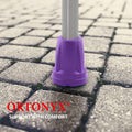 Purple ORTONYX crutch tips, one shown on aluminum shaft gripping pavers; walking aid tip replacement HDG920115X2