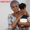 Infant wearing ORTONYX Baby Umbilical Hernia Belt OX350 VCOX350, black elastic abdominal band; pediatric hernia truss.