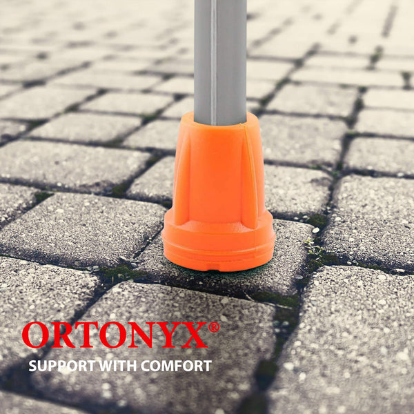 Orange ORTONYX crutch tip close-up on paver stones, high-visibility replacement tip for consistent ground contact.