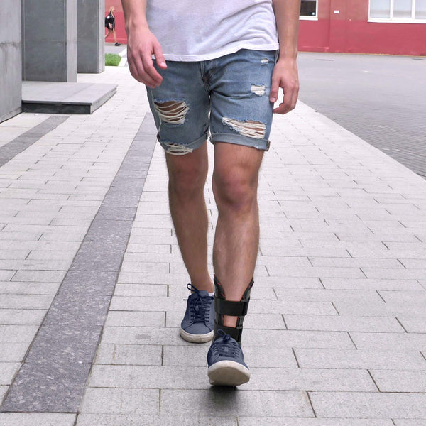 Person walking wearing Ankle Stabilizer Brace stabilizing stirrup splint with rigid shells and two hook-and-loop straps